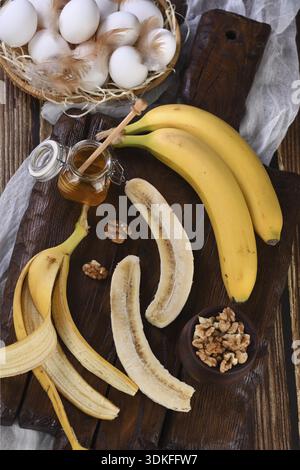 Lebensmittel, Bananen, Nüsse, Eier, Honig - Zutaten zum Backen von selbstgemachtem Bananenbrot Stockfoto