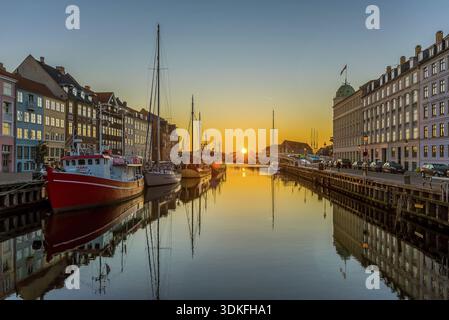 Den Sonnenaufgang über dem ruhigen Wasser des Nyhavn, den Hafen und die Boote in der ruhigen Oberfläche, Kopenhagen, 16. Februar 2019 Stockfoto