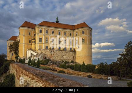 Mikulov, Tschechische republik - 10 02 2018: Barockschloss Mikulov, asphaltierte Straße im Vordergrund, Herbstabend Stockfoto