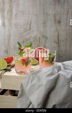 Essen, Cocktail aus Saft gepresste rote Grapefruit und Blätter von zartem Zitronenbasilikum, Limettenscheiben und gekühlte Eiswürfel Stockfoto
