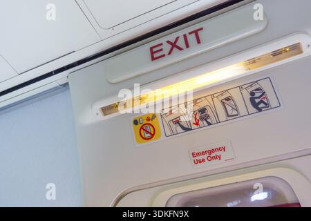 Ausstiegsschild und Symbole über der Tür in einer Flugzeugkabine Stockfoto