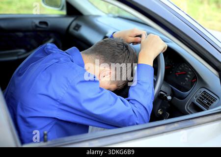 Junger Mann schläft in einem Auto ein Stockfoto