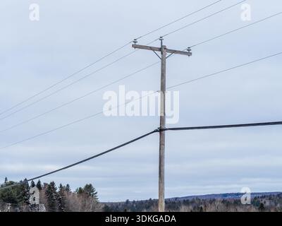 Hölzerner Versorgungsmast mit Überlandstrom- und Kommunikationsleitungen. Quebec, Kanada Stockfoto
