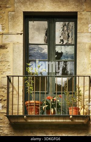 Spanisches Fenster mit Balkon, dekoriert mit frischen Blumen, Vintage-Stil Stockfoto