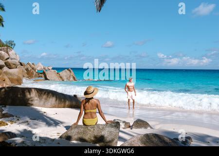Ein Paar genießt einen romantischen Tag auf dem unberührten Sand von Anse Georgette, umgeben von üppigen Palmen und atemberaubendem türkisfarbenem Wasser. Praslin Seychelle Stockfoto