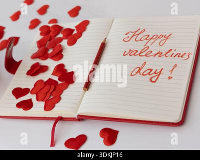 Happy Valentines Day handgeschriebener Text offenes Notizbuch, rote Herzen, horizontale Weitwinkelansicht von oben Stockfoto