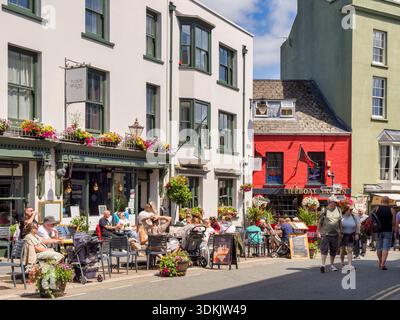 Tenby High Street, voll mit Menschen, vor Cafés sitzen, spazieren gehen, die warme Sommersonne genießen, während der Hitzewelle im Juli. Pembrokeshire, Stockfoto