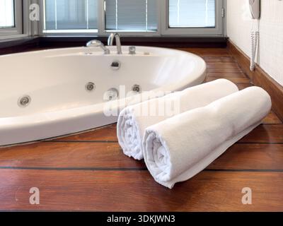Luxuriöses Hotelbad mit Whirlpool und sauberen weißen Handtüchern Stockfoto