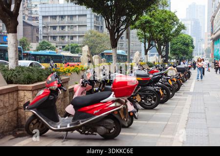 Chongqing China 4,7.2025. Eine Reihe geparkter Motorräder auf einem Bürgersteig vor einem Gebäude. Die Szene ist ruhig und friedlich, und niemand ist da Stockfoto