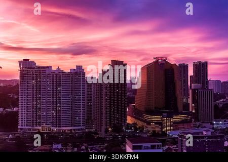 Dramatischer Abendhimmel mit bunten Wolken über Hochhäusern und Hotels Stockfoto