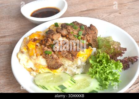 Gegrilltes Schweinerippchen Dipping scharfe Chili Thai Sauce mit Spiegelrahm Ei Omelett auf Reis in Teller Stockfoto