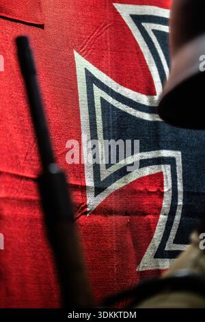 Soldatengewehr in der Nähe der Nazi-Flagge in historischer Umgebung aus der Zeit des Zweiten Weltkriegs Stockfoto