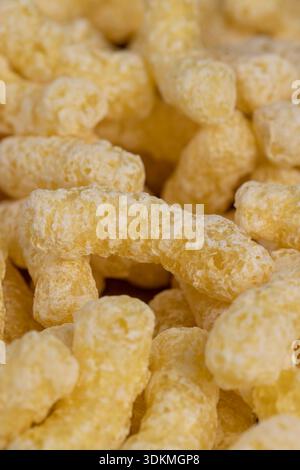 Gelbe große Zuckerstangen mit Zuckerzusatz zum schnellen Kochen mit Milch oder Joghurt, verzehrfertige Maisstangen auf Lebensmittelpapier Stockfoto