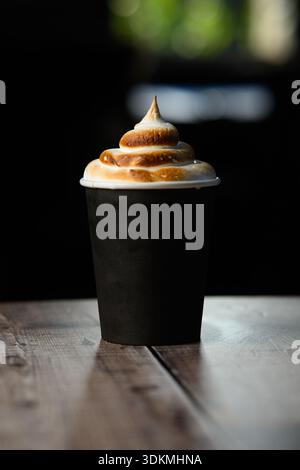 Eine Tasse Kaffee mit Schlagsahne. Die Schlagsahne hat die Form einer Spirale Stockfoto