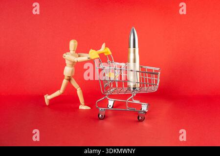 Holzpuppe läuft und schiebt einen Sopping Cart mit einer Bombe oder Kartusche auf rot Stockfoto