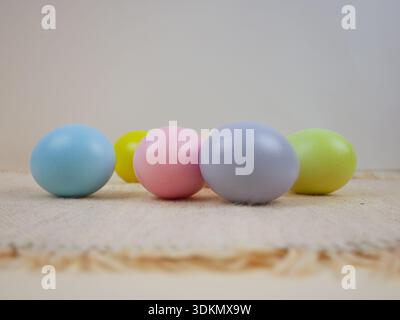 Hintergrund der Osterferien. Pastellfarbene Eier werden zur Dekoration auf eine strukturierte Oberfläche gelegt Stockfoto