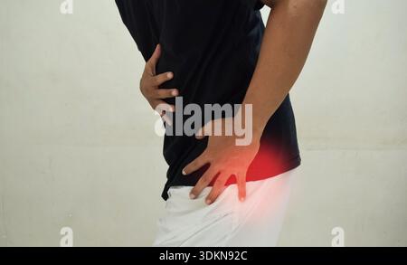 Hüftschmerzen, Mann mit Arthrose zu Hause. Das Konzept der Gesundheitsprobleme Stockfoto