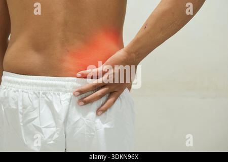Ein Mann leidet unter Schmerzen im unteren Rücken. Das Konzept der Gesundheitsprobleme Stockfoto