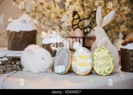 Schlafender weißer Hase mit Osterkeksen und Dekor für Frühlingsfeiertage Stockfoto