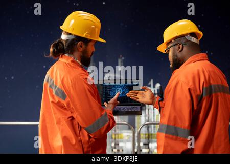 Offshore-Plattform-Engineering-Team, das vorausschauende KI-Modelle verwendet, um den Wartungsbedarf der Ausrüstung vorherzusagen. Mitarbeiter von Bohrgeräten analysieren maschinelle Lerndaten auf dem Armaturenbrett, um mechanische Ausfälle zu vermeiden Stockfoto
