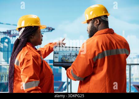 Offshore-Plattform-Engineering-Team mit Laptop-Software-Schnittstelle zur Verfolgung der Produktionseffizienz. Das Bohrfahrzeug-Team verwendet das Armaturenbrett für das Notebook-Programm, um die Sensorwerte der Ausrüstung zu überprüfen Stockfoto