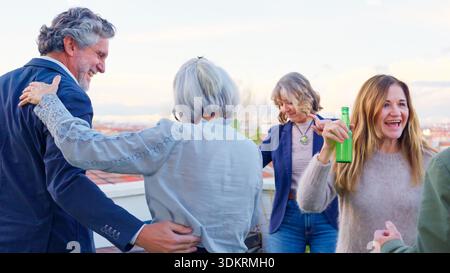 Die Leute genießen eine lebhafte Dachparty mit Drinks Stockfoto