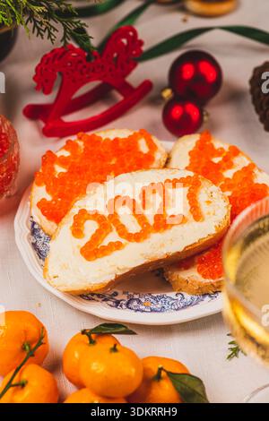 Ein Sandwich mit Butter und Kaviar. Die Zahlen für 2027 sind in Punkten dargestellt. Stockfoto
