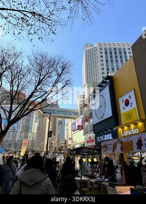 Seoul, Südkorea – 26. Februar 2023: Überfüllte Straße mit Imbissständen und Fußgängern Stockfoto