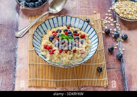 Dicker schottischer Haferbrei mit frischen Blaubeeren und Preiselbeeren Stockfoto