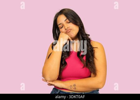 Junge Frau, die sich langweilig und schläfrig fühlt, während sie ihren Kopf auf der Hand hält Stockfoto