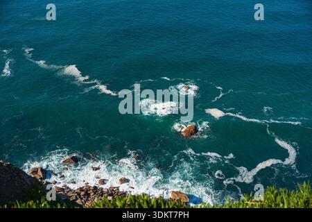 Felsige Küste und Meereswellen von der Klippe aus gesehen, Cascais, Portugal Stockfoto