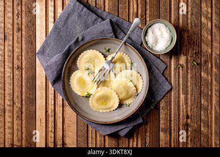 Hausgemachte Ravioli Pasta Teller von oben mit Parmesan-Käsegabel Serviette auf Holztisch Hintergrund Stockfoto