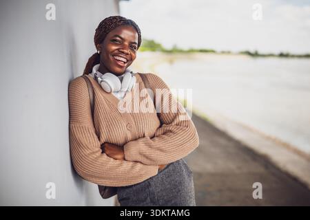Außenporträt einer jungen glücklichen schwarzen Frau mit Zahnspangen. Sie schaut in die Kamera und lächelt. Stockfoto
