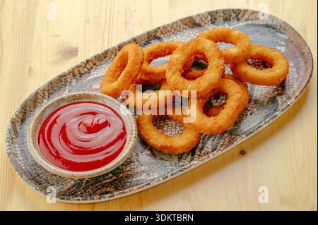 Gebratene Zwiebelringe mit Sauce auf einem Teller Stockfoto