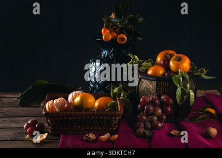 Dunkles Stillleben mit frischem Obst und Blumen Stockfoto