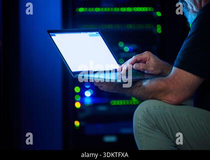Nahaufnahme eines Mannes, der ein Notebook im Rechenzentrum verwendet Stockfoto