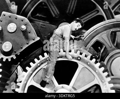 Dieses legendäre Destillier aus dem Film „Modern Times“ aus dem Jahr 1936 zeigt Charlie Chaplin als seine Figur „The Tramp“, die in unsicheren Situationen inmitten riesiger industrieller Gänge gefangen wurde. Die Szene satirisiert die entmenschlichenden Auswirkungen der Industrialisierung und die Herausforderungen, denen die Arbeiterklasse während der Großen Depression gegenübersteht. Stockfoto