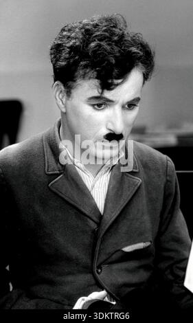 Ein nachdenkliches Nahporträt von Charlie Chaplin in der Rolle des Tramp aus den 1930er Jahren Sein unverwechselbares, lockiges dunkles Haar, der Schnurrbart der Zahnbürste und sein tiefer Blick sind in diesem Schwarz-weiß-Bild, einem Standbild aus seinem legendären Film „Modern Times“, hervorzuheben. Stockfoto