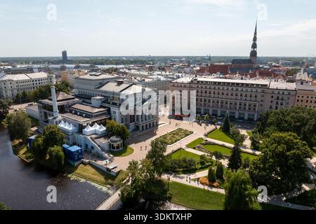 Stadtblick auf Riga, Lettland, mit dem Denkmal der Freiheit, der Lettischen Nationaloper in der Nähe eines Kanals und dem Turm der Peterskirche im Hintergrund. Stockfoto