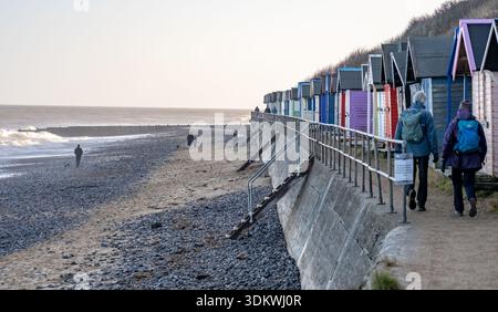Hölzerne Strandhütten entlang der Promenade in der Küstenstadt Cromer an der Küste von Norfolk. An einem kalten Wintertag festgehalten Stockfoto