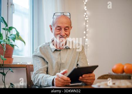 Ein älterer Mann, der ein Tablet benutzt, online einkaufen will. Stockfoto