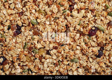 Glutenfreies Hafergranola mit Nüssen und Beeren. Textur Haferflockengranola oder Müsli als Hintergrund, Draufsicht Stockfoto