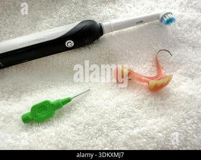 Eine elektrische Zahnbürste und Zahnprothetik und ein tepe Interdentalreinigungswerkzeug, auf einem weichen Handtuch angeordnet, um die Zahnhygiene zu pflegen Stockfoto