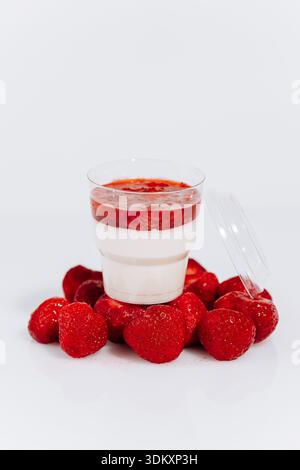 Erdbeere Panna Cotta in Tasse mit frischen Beeren auf weißem Hintergrund Stockfoto
