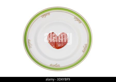 Scheiben von Wurst in der Form eines Herzens auf einen alten Teller Stockfoto