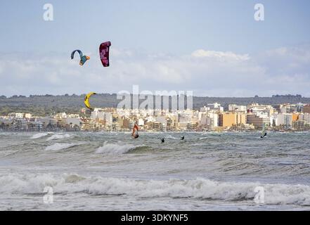 CAN PASTILLA, MALLORCA, SPANIEN - 6. APRIL 2019: Surfer in die grünen Wellen spielen an einem windigen, sonnigen Tag am 6. April 2019 in Can Pastilla, Mallorca, Sp Stockfoto