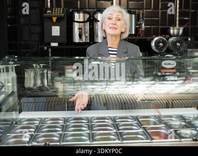 Lächelnde Senior Verkäuferin, die erfrischenden taiwanesischen boba-Tee anbietet Stockfoto