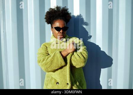 Porträt der jungen Erwachsenen Schwarzen Frau mit Sonnenbrille im Freien stehend Stockfoto