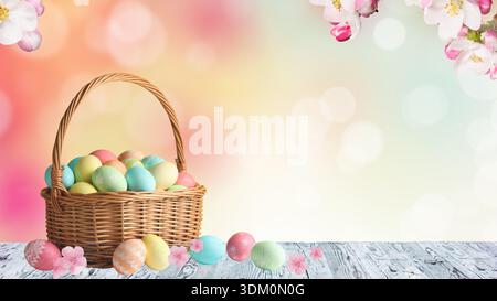 Korb mit bunten bemalten ostereiern und Frühlingsblumen auf einem Holztisch mit weichem Bokeh-Hintergrund Stockfoto