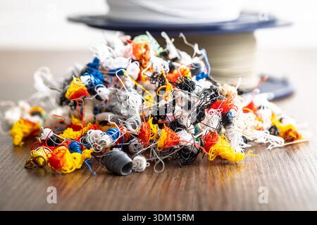 Abfall des 3D-Druckers. Plastikfäden kacken auf einen Holztisch. Stockfoto